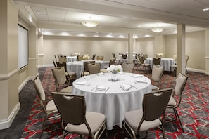 A conference room with round tables, chairs, and floral centerpieces. - Best Western Premier Plainview-Long Island Hotel (Plainview)