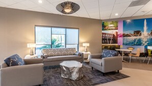 A modern living room with a sofa set, two armchairs, a coffee table, and a dining area with a table and chairs.