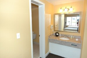 A bathroom with a sink, mirror, and towel rack.
