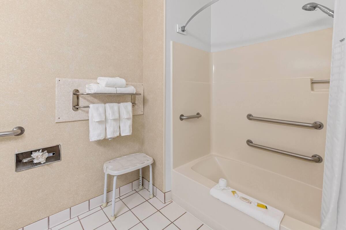 Un baño con ducha, inodoro, lavabo y toallero.