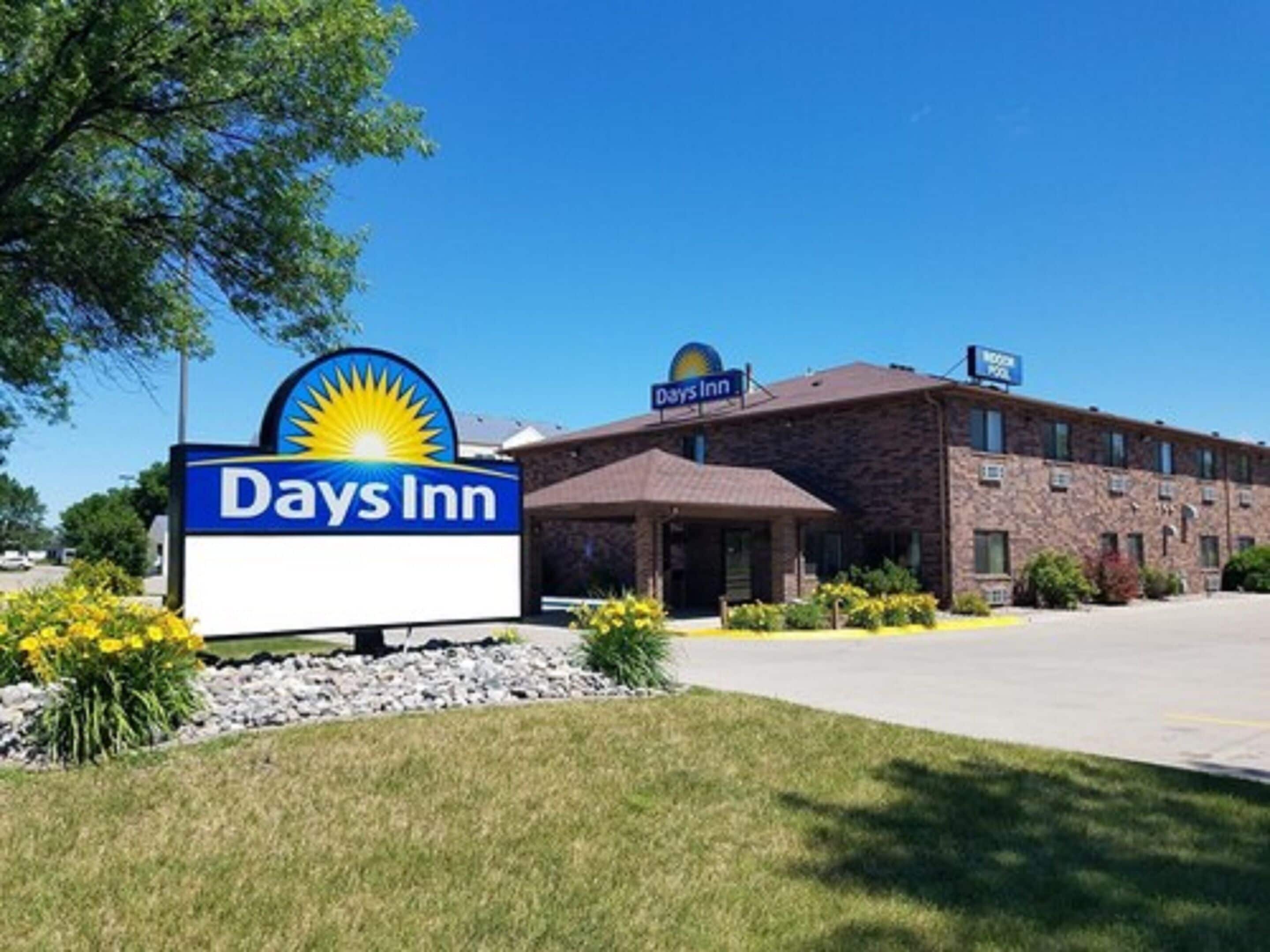 A Days Inn hotel with a clear sign, a brick building, and a parking lot.