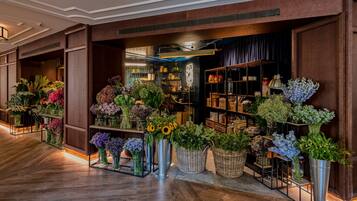 A floral shop with various plants displayed in metal and wicker containers.