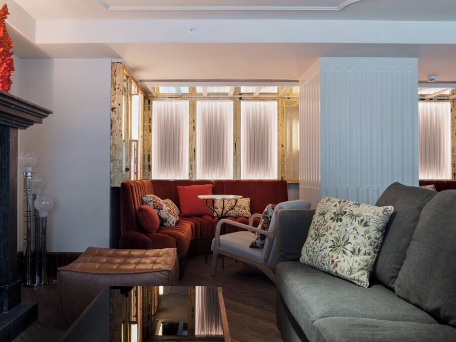 Una sala de estar moderna con un sofá, sillones y una mesa de centro.