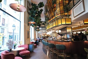 Un bar moderno con asientos, barra y grandes ventanales.