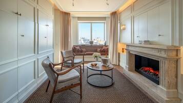 Habitación de hotel con chimenea, zona de estar y vistas a la ciudad.