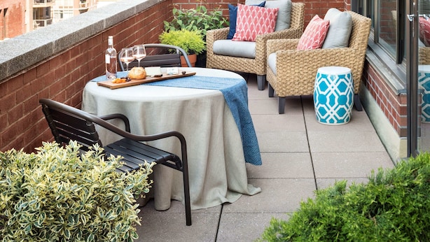 Een terras op het dak met een eettafel, buitenzitplaatsen en uitzicht op de stadshemel.