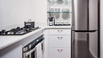 A modern kitchen with a stainless steel refrigerator, a gas stove, a coffee maker, and a microwave.