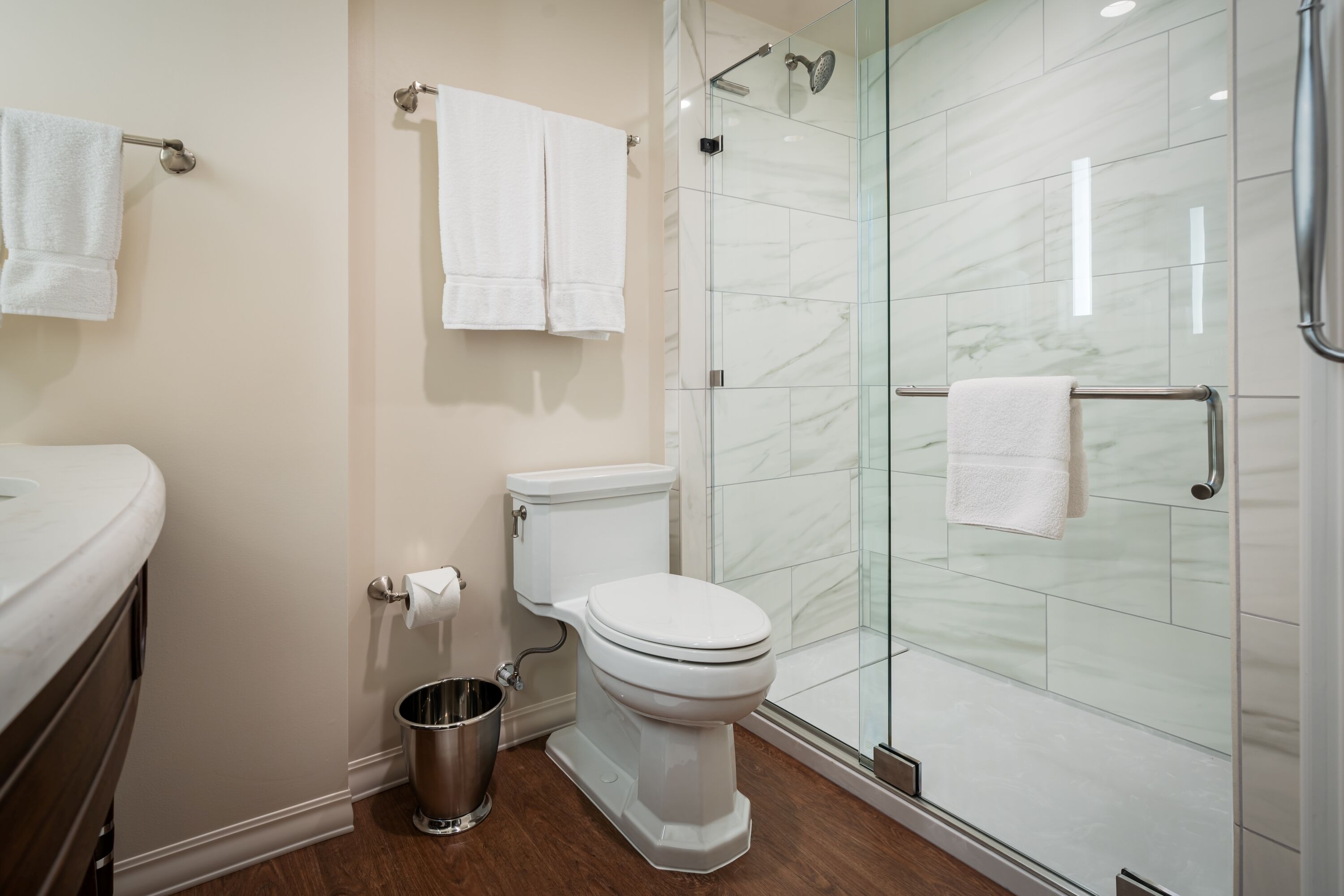 A modern bathroom with a toilet, bidet, and glass shower enclosure.