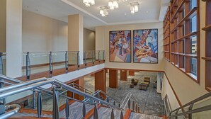 A hotel lobby with a marble floor, a staircase, and artwork on the walls. - Hyatt Regency DFW International Airport - Adjacent to Terminal C (Dallas)