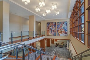 A hotel lobby with a marble floor, a staircase, and artwork on the walls. - Hyatt Regency DFW International Airport - Adjacent to Terminal C (Dallas)