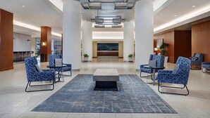 A spacious lobby with modern furniture, a reception desk, and a large decorative wall. - Hyatt Regency DFW International Airport - Adjacent to Terminal C (Dallas)