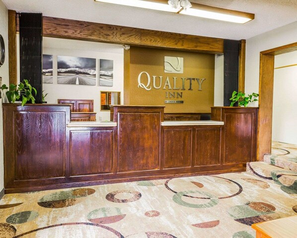 A reception desk with a sign reading "Quality Inn" and a logo above it. - Quality Inn Pagosa Springs (Pagosa Springs)