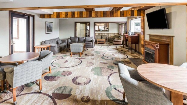 A spacious living area with a fireplace, multiple seating arrangements, and a television mounted on the wall. - Quality Inn Pagosa Springs (Pagosa Springs)