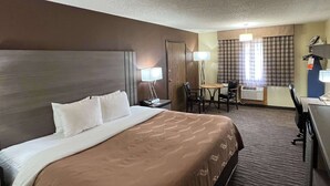 A hotel room with a large bed, a desk, a chair, and a table. - Quality Inn Pagosa Springs (Pagosa Springs)