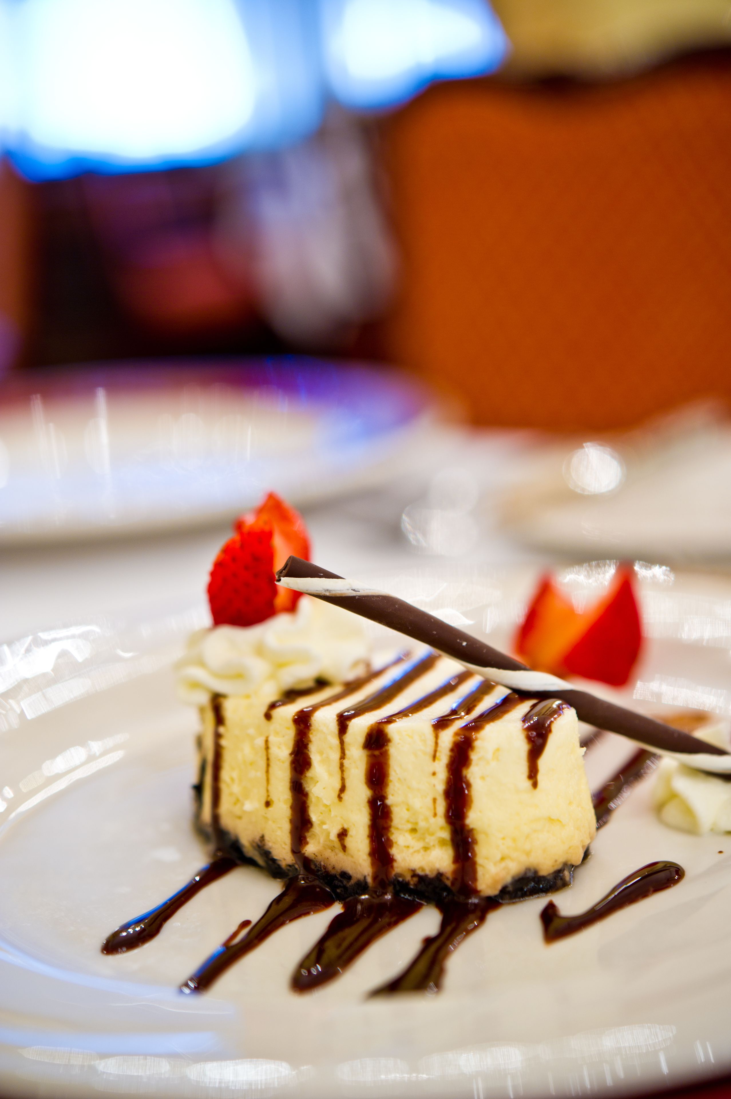 Sobremesa com calda de chocolate e morango em um prato.