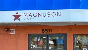 The exterior of the Magnuson Hotel with a blue awning, a fire alarm sign, and the address number 6511. - Magnuson Hotel Bradenton (Bradenton)