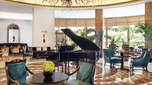 A grand lobby with a grand piano, elegant chairs, a chandelier, and large windows with a view of greenery. - InterContinental Madrid by IHG (Madrid)