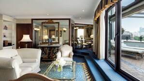 A hotel room with a large window, a sofa, a chair, a table with a vase of flowers, and a mirror. - InterContinental Madrid by IHG (Madrid)