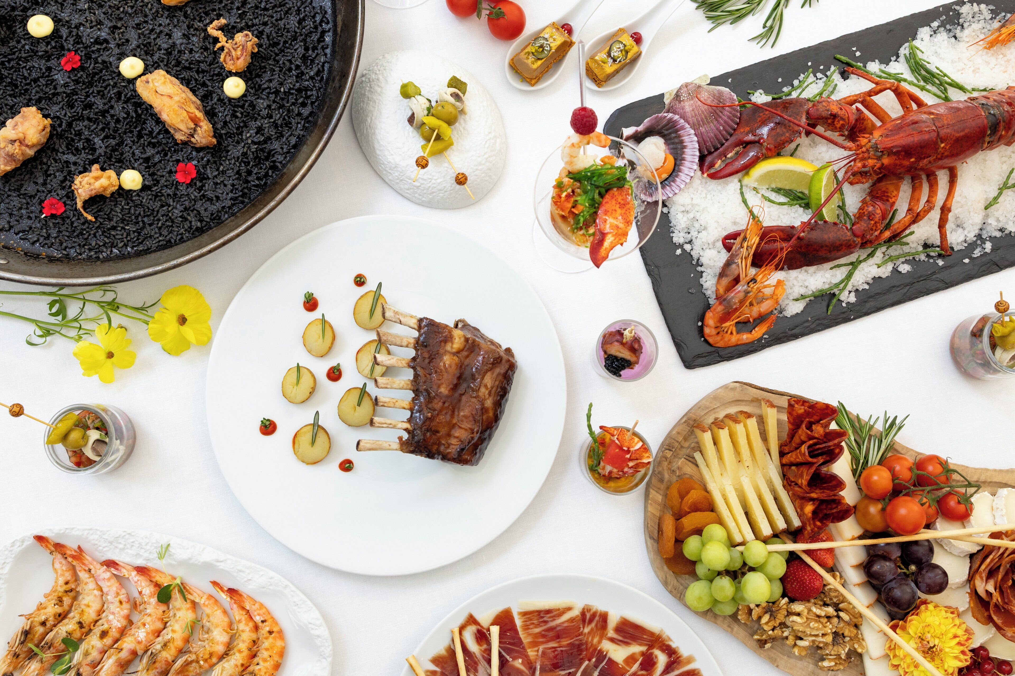 A variety of food items including seafood, cheese, and fruits arranged on a table.