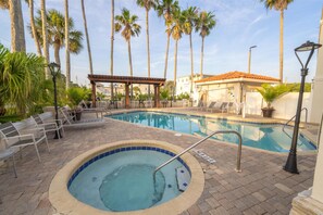 A swimming pool with a hot tub, lounge chairs, and palm trees. - Best Western Seaside Inn (St. Augustine)