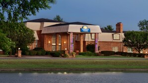 Un hôtel Days Inn avec une façade en briques, de grandes fenêtres et une enseigne au-dessus de l’entrée.