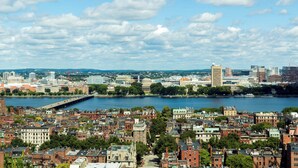 A cityscape with a river, historic buildings, and a bridge.