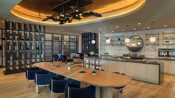 Una cocina moderna con una isla central, estanterías empotradas e iluminación colgante.