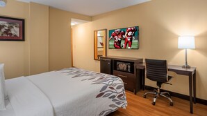 A hotel room with a bed, desk, chair, and a lamp. - Red Roof Inn Des Moines (Des Moines)