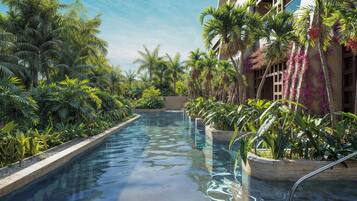 Relax by the serene pool surrounded by lush tropical vegetation and vibrant plants.