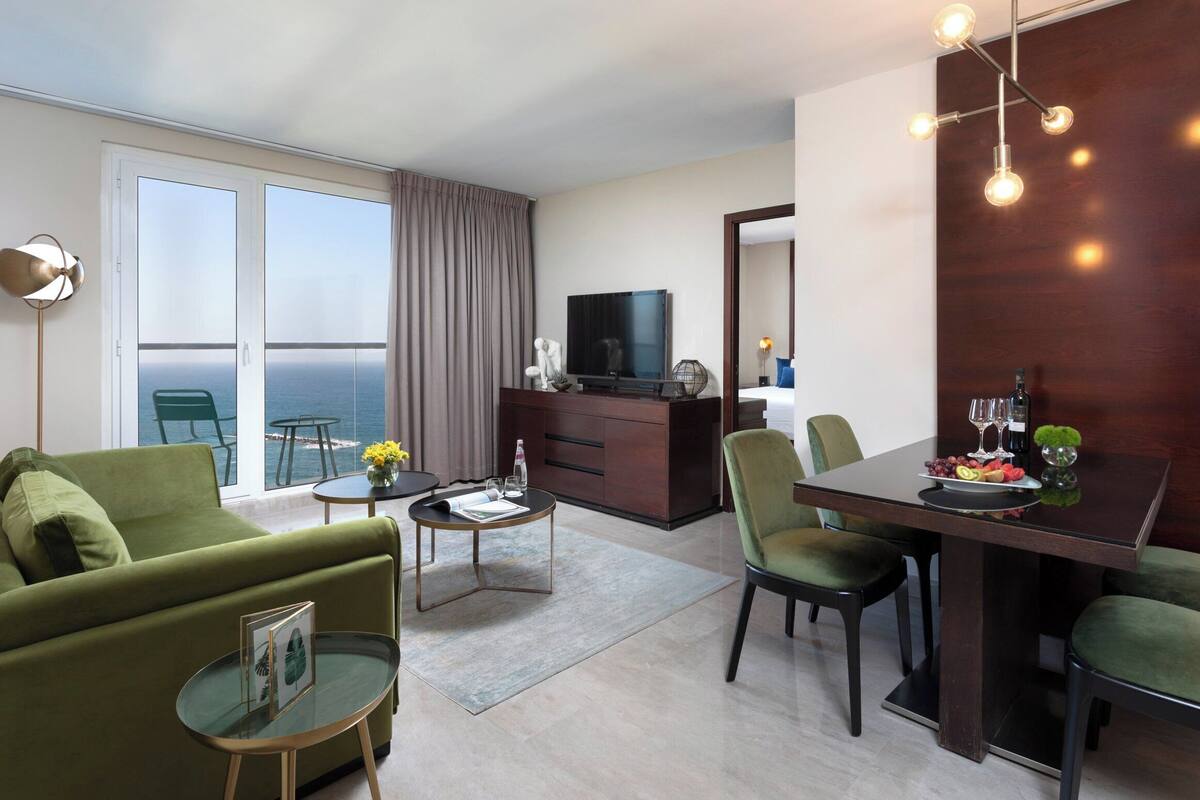 Une chambre d’hôtel moderne dotée d’un balcon, d’un coin repas et d’un espace de vie.