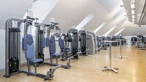 A gym with multiple Nautilus machines, wooden flooring, and a high ceiling with skylights. - Central Plaza Hotel (Zürich)