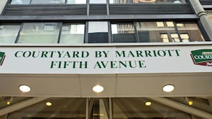 A high-rise building with a sign reading "Courtyard by Marriott Fifth Avenue."