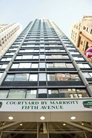 A high-rise building with a sign reading "Courtyard by Marriott Fifth Avenue."
