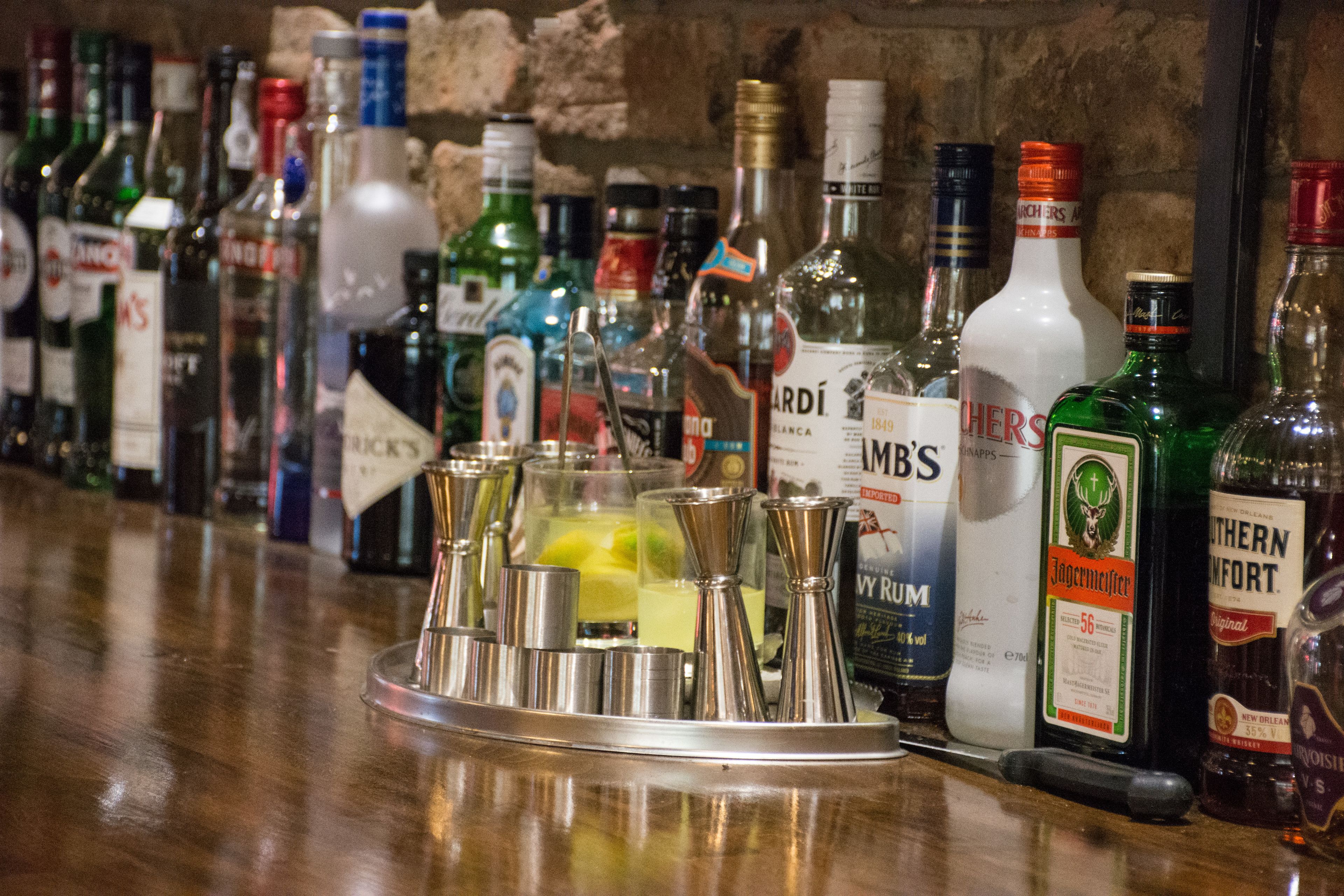 A bar with various liquor bottles and a tray of glasses.