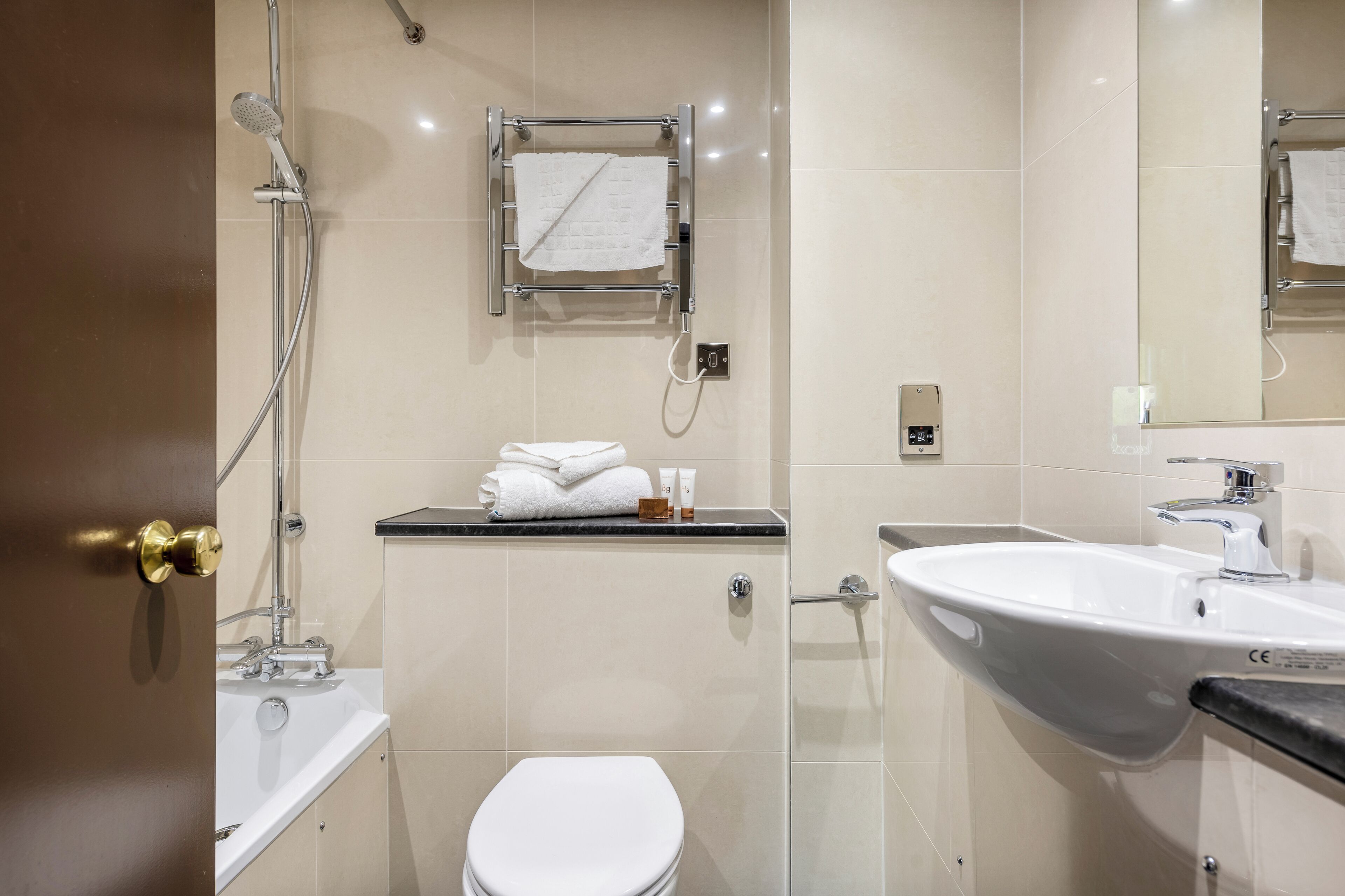 A modern bathroom with a toilet, sink, and shower.