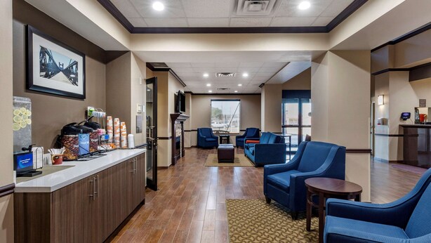 A hotel lobby with a reception desk, seating area, and a large window.