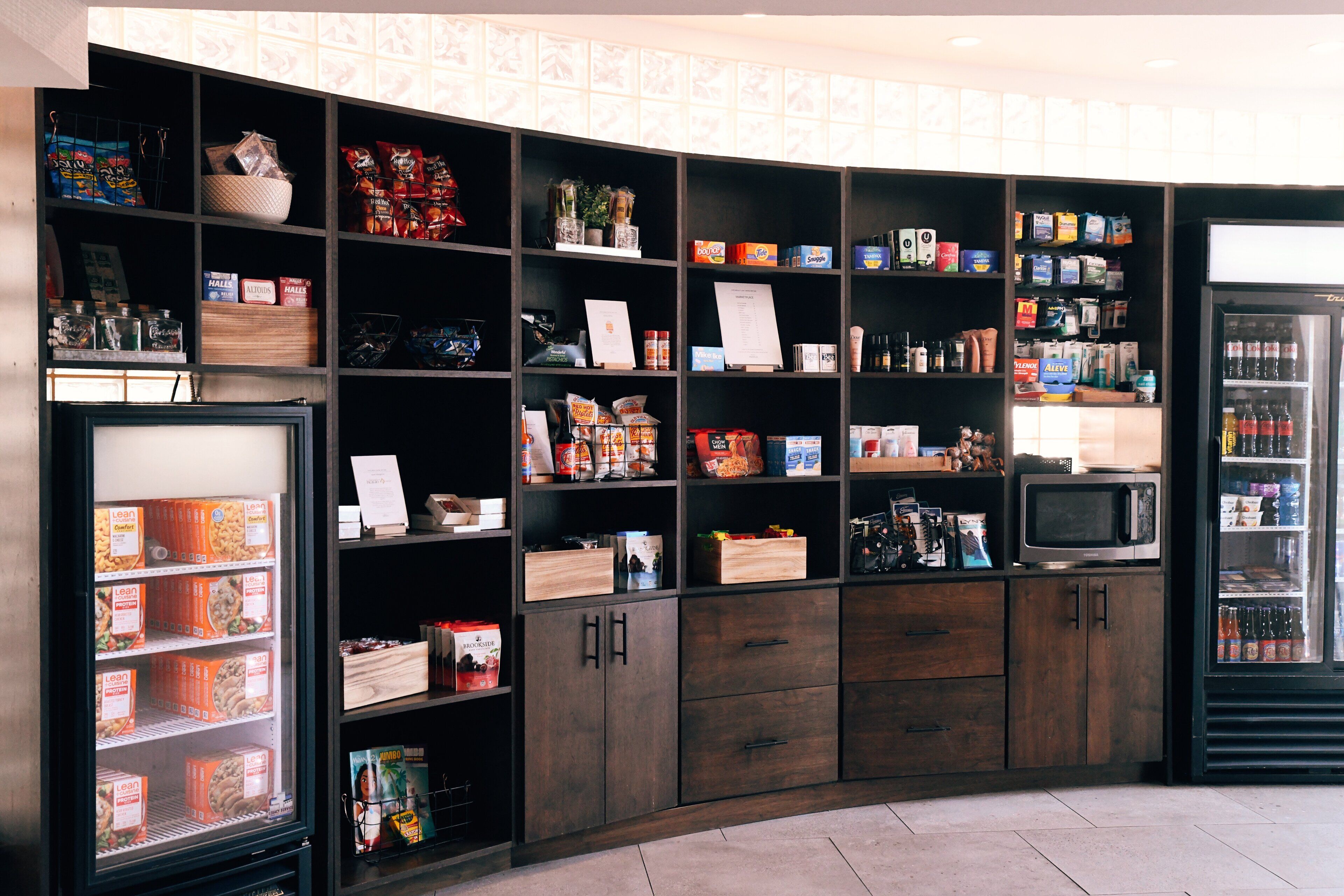 A well-organized kitchen area with various food items, a microwave, and a refrigerator.