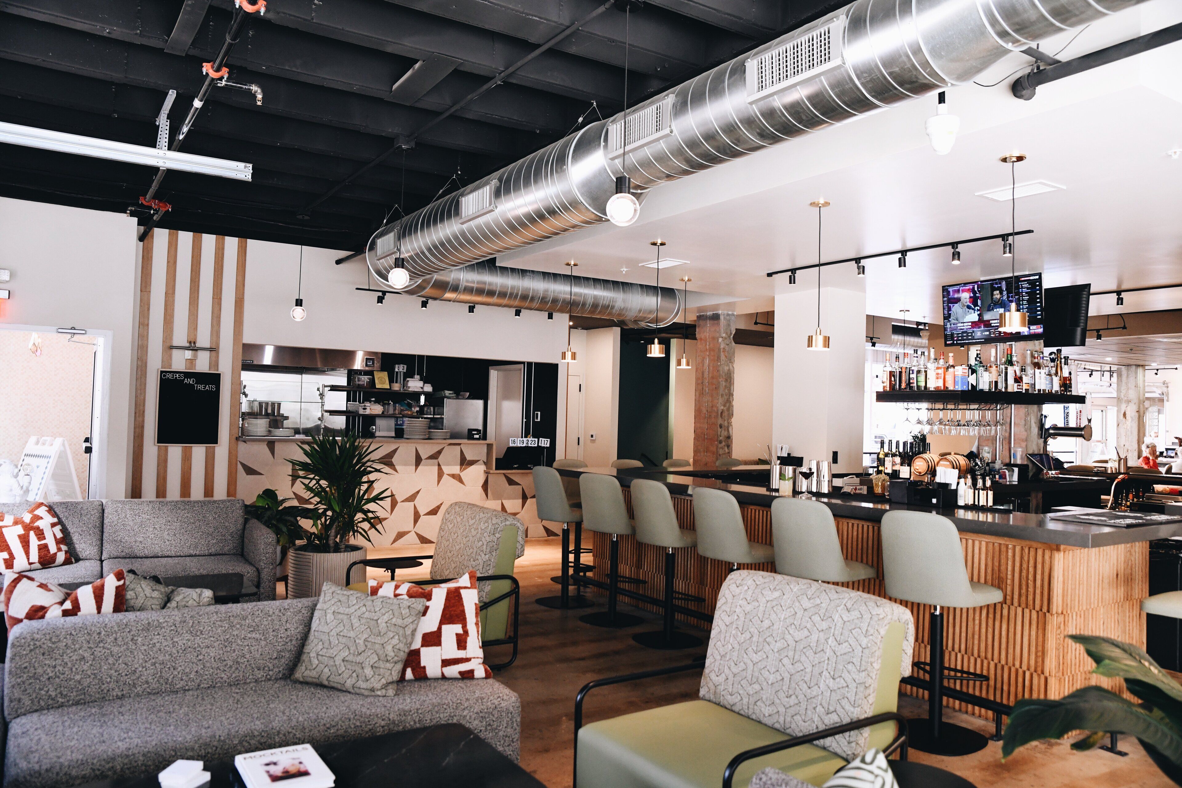 A modern interior with seating areas, a bar, and a kitchen.