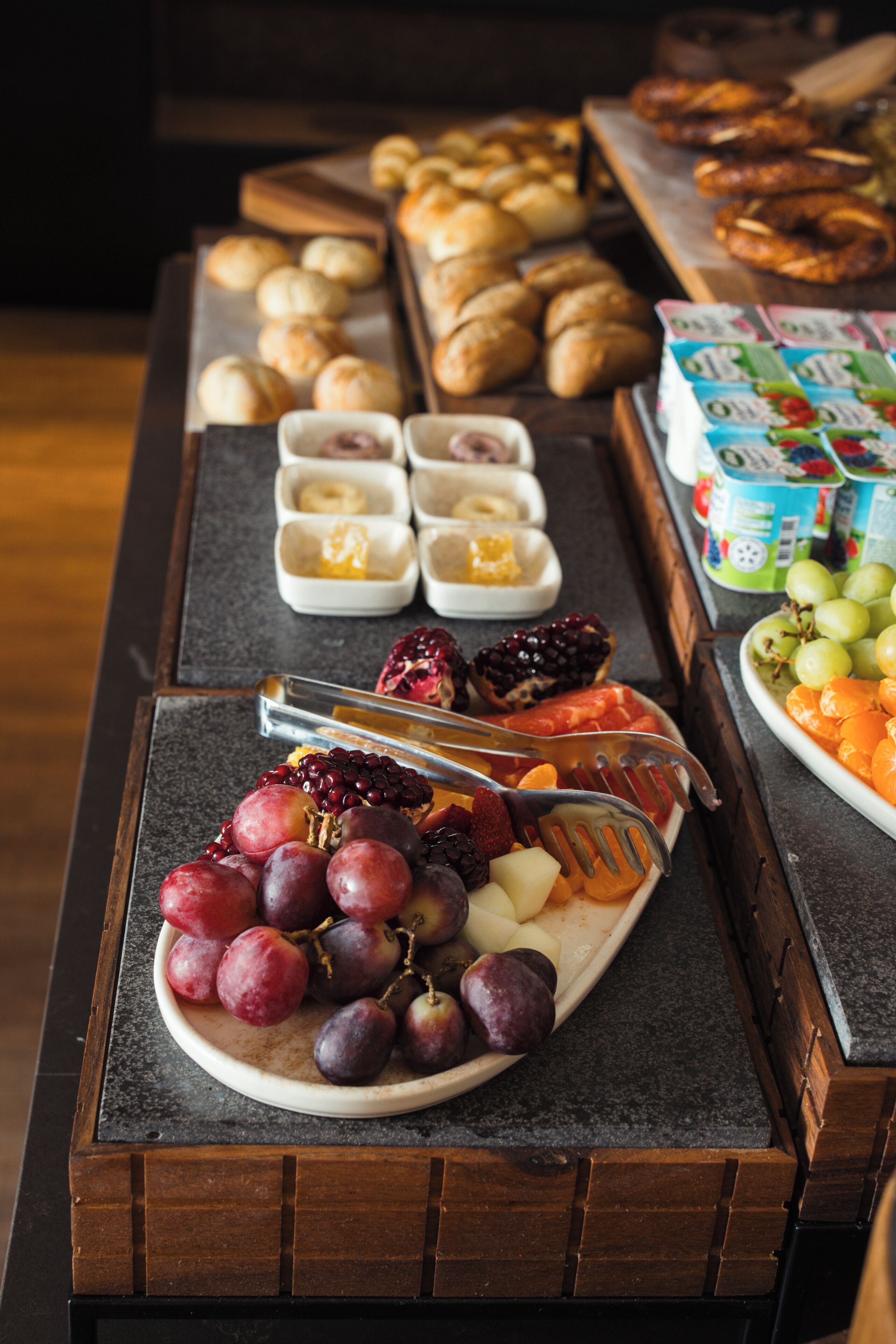 A breakfast buffet with various pastries, fruits, and dairy products.