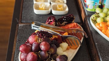 A breakfast buffet with various pastries, fruits, and dairy products.