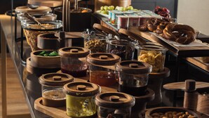 A buffet setup with various food containers and a fruit tree. - DoubleTree by Hilton Istanbul Macka (Istanbul)