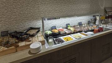 Een buffet met diverse gerechten en een melkstaanplaats.