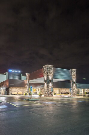 A Wyndham hotel with a modern design, featuring stone pillars and a prominent sign. - Wyndham Chicago O'Hare (Des Plaines)