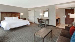A hotel room with a bed, desk, chair, and a small table. - Hampton Inn & Suites Alexandria Old Town Area South (Alexandria)
