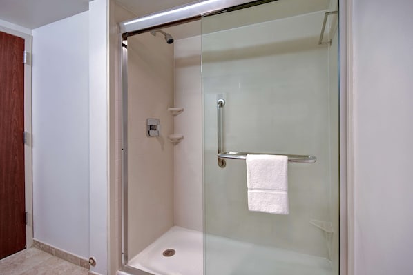 A glass-enclosed shower stall with a white towel hanging on a metal bar. - Hampton Inn & Suites Alexandria Old Town Area South (Alexandria)