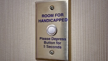 A metallic switch labeled "ROOM FOR HANDICAPPED" with a note instructing to depress the button for 5 seconds.
