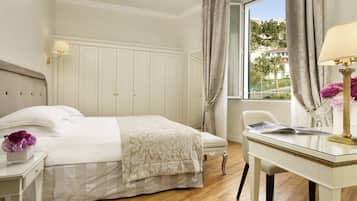Une chambre d’hôtel avec un lit, un bureau et une fenêtre avec des rideaux.