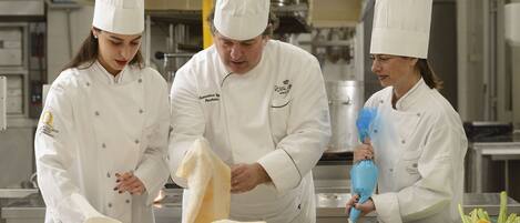 Three chefs in a professional kitchen preparing food.