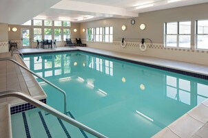 Una piscina techada, una piscina al aire libre de temporada, sombrillas