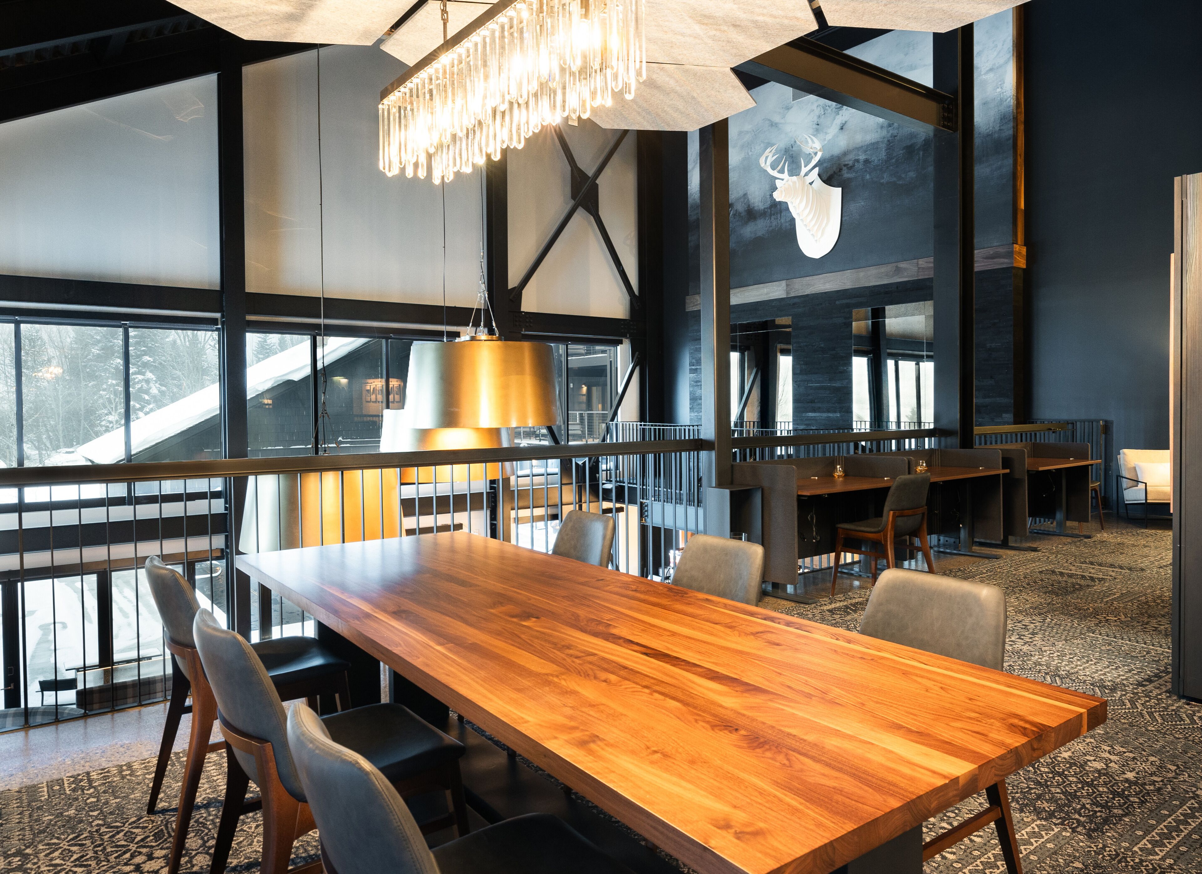 Un espace de salle à manger moderne avec une table en bois, des chaises et un lustre.